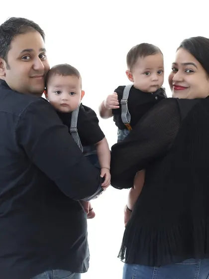 A beautiful family portrait with mom, dad, and their twin boys. Coordinating in simple black outfits creates a timeless look that highlights the connection and love within the family.