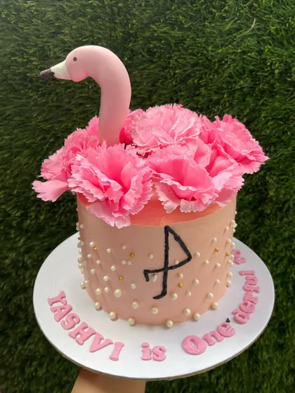 A tropical flamingo cake for a first birthday. This design uses fresh pink carnations to create the flamingo's feathers, with minimal fondant for a beautiful and delicious result.
