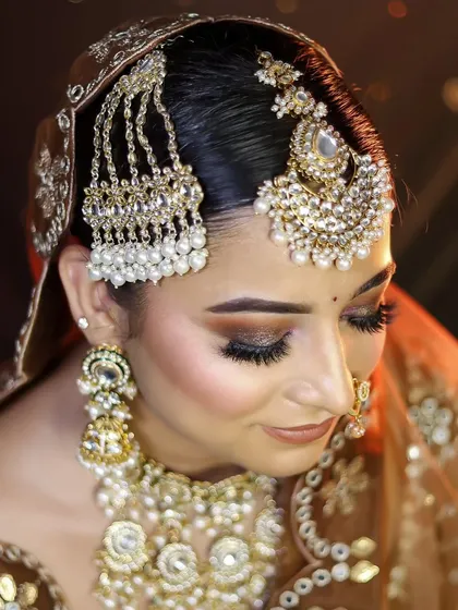A close-up of a bride with elaborate hair jewelry, including a passa and maang tikka. My hair courses cover the secure and aesthetic placement of all types of bridal hair accessories.