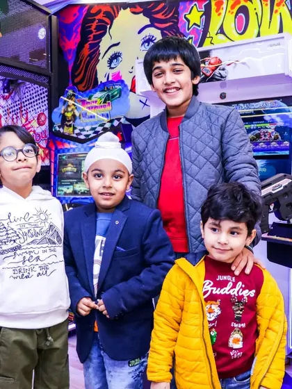 A group of friends posing for a photo in the middle of the arcade. It's a great place for kids to bond and make new friends over some friendly competition.