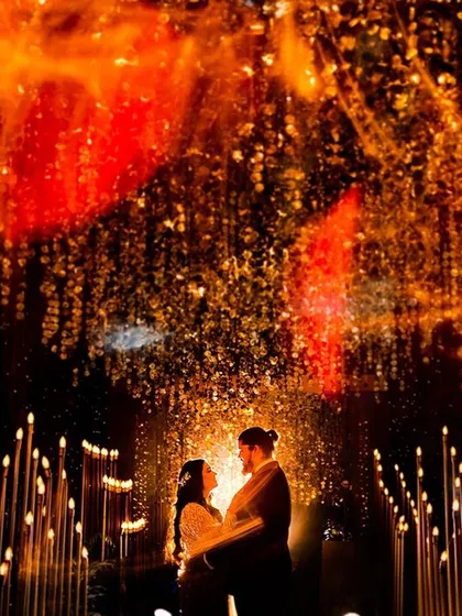 Under a sky of explosive, fiery lights, this couple is silhouetted in their own world. This artistic Sangeet portrait is all about capturing the grand energy and drama of the celebration in a single, powerful frame.