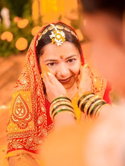 A close-up of the bride's face as Haldi is gently applied, her shy smile capturing the sweetness of the moment.