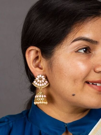 A lovely client wearing our pink lotus meenakari jhumkas. These copper-based earrings are lightweight and feature beautiful hand-painted details, perfect for adding a feminine touch to your look.