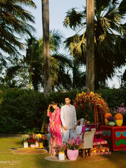 A beautiful shot of the couple at their colorful Mehendi ceremony, surrounded by vibrant decor and lush greenery.