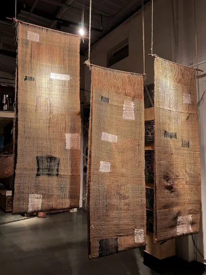 Three hand-woven panels from 'Cu+Fibers' hang in our studio. Made from jute and upcycled cotton, these pieces explore texture and transparency, with patches of different weaves creating a subtle rhythm.