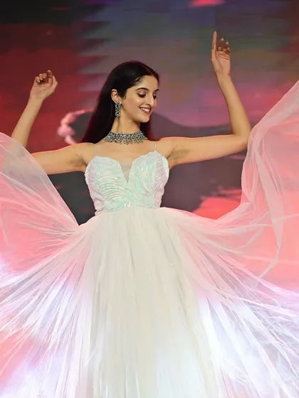 A dynamic shot on the runway, with the gown in full flight. The makeup is designed to keep the focus on her face, ensuring she shines on stage.