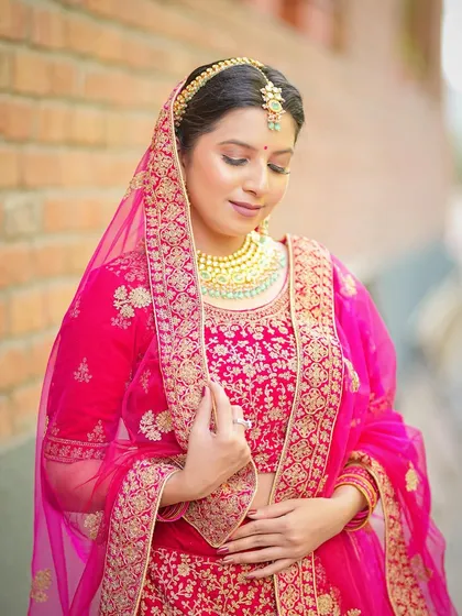 A classic bridal pose, with the model adjusting her dupatta.