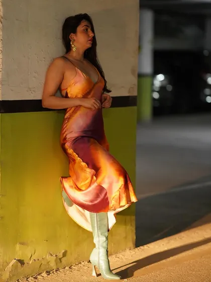 A side view of the colorful dress, paired with statement boots for an edgier look.