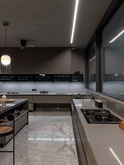 This angle highlights the kitchen's layout, designed for both large-scale entertaining and daily family use. The combination of natural light and layered artificial lighting creates a welcoming ambiance day or night.