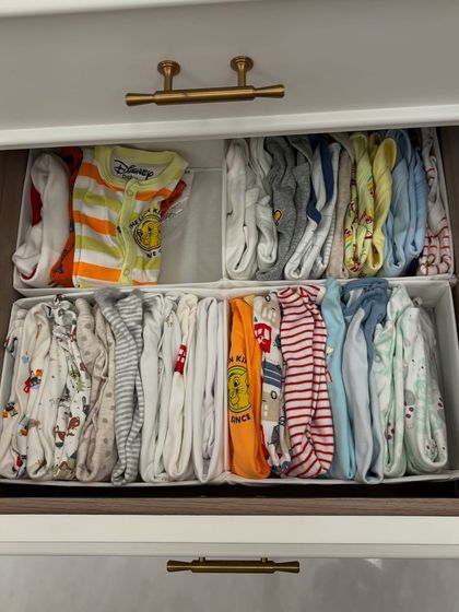 A drawer full of adorable, file-folded baby clothes. This method allows parents to see every outfit at a glance, making dressing a wriggly little one much faster.