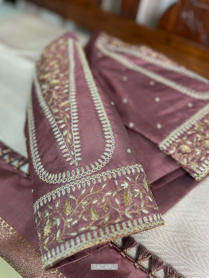 A blouse in subtle hues of dusky rose and ice blue, featuring refined embroidery details on the sleeves.