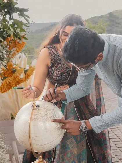 For a destination wedding, we love incorporating unique guest activities. Here, the couple signs a custom-curated globe, creating a beautiful keepsake of their journey and the places they'll go together.