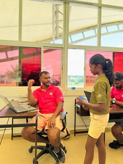 Coach Kiran reviewing a student's work. He sets high standards and gives each student his full attention, whether they are a young junior or an adult beginner.