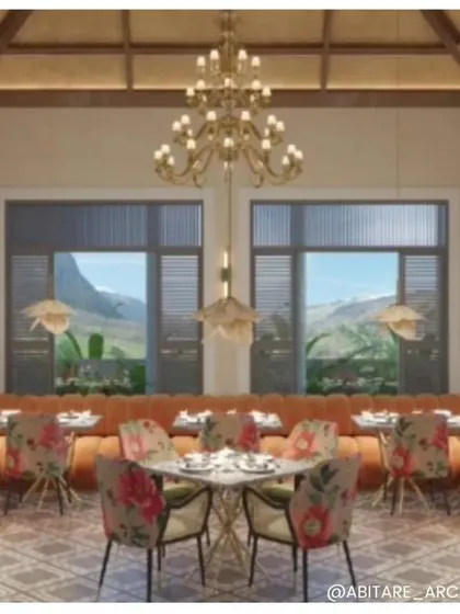 The dining area of our Nahan hotel project, designed as a visual masterpiece. The space features floral-patterned chairs, an orange banquette, and large windows that frame the mountain views, creating an opulent dining experience.