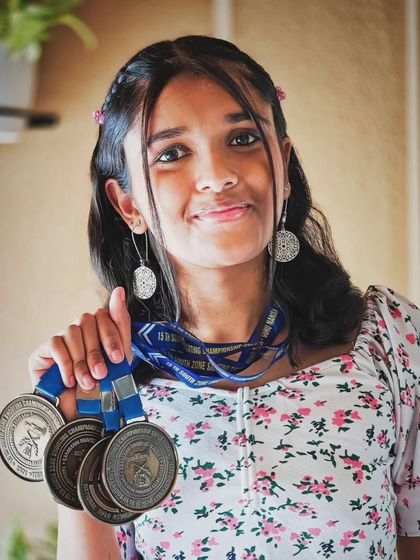 One of our talented young shooters showcasing the medals she has earned through dedicated training and competition. We celebrate every victory on the path to excellence.