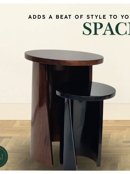 A pair of nesting tables in a dark, high-gloss finish. The curved, sculptural forms allow them to be used together or separately, offering versatile and stylish surfaces for any room.