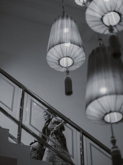 An artistic black and white bridal portrait, using low angles and architectural elements to create a moody and dramatic image.