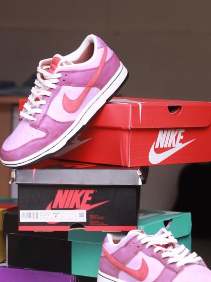 The "Velvet Plum" custom Dunks sitting on a stack of Nike boxes. The rich plum and pink tones are so beautiful.