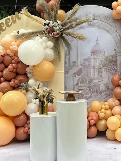 This elegant first birthday setup combines the rustic feel of boho decor with the romance of Bridgerton, using a palette of peach, terracotta, and cream balloons.
