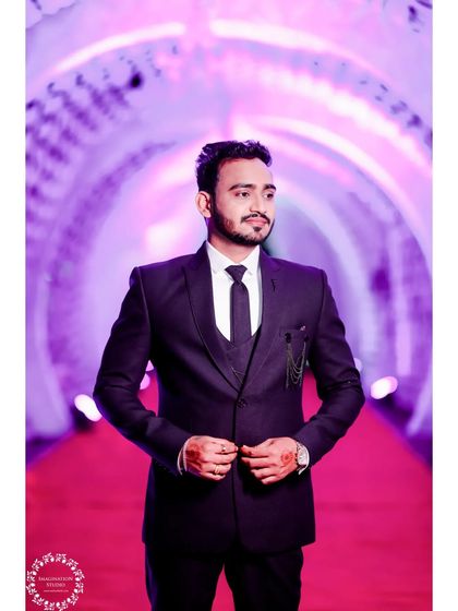 A Maharashtrian groom's reception look. The dark suit is a classic choice for the evening celebration, providing a great contrast to the traditional wedding attire.