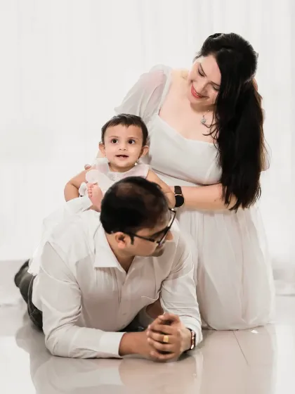 A lovely family of three enjoying a quiet moment together. Our all-white studio setup is perfect for creating clean and timeless portraits.