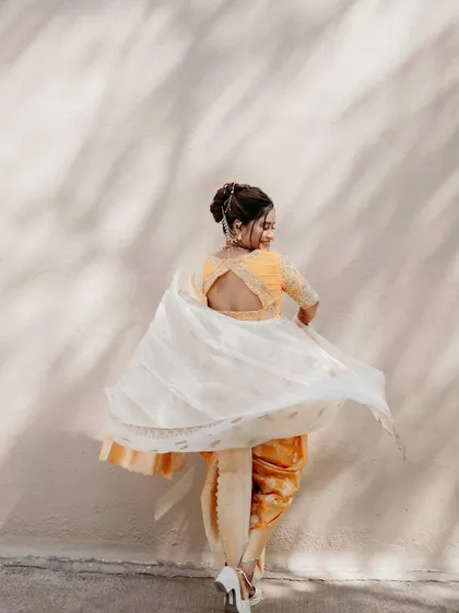 A dynamic shot showing the movement of the Nauvari saree and the elegant keyhole back design of her blouse.