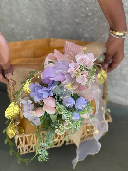 A single, beautifully crafted hamper basket, showcasing the intricate floral arrangement and warm glow of fairy lights. This image highlights the individual care and attention we put into every gift we create.
