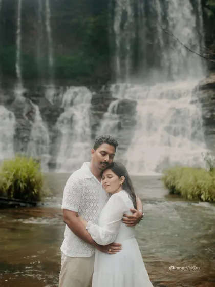 A peaceful embrace in front of the cascading water. The couple holds each other close, their serene expressions reflecting the tranquility of the natural surroundings.