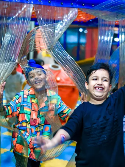 A candid shot of two friends laughing as they navigate a flexible tunnel. It's moments like these that make playtime here so memorable.