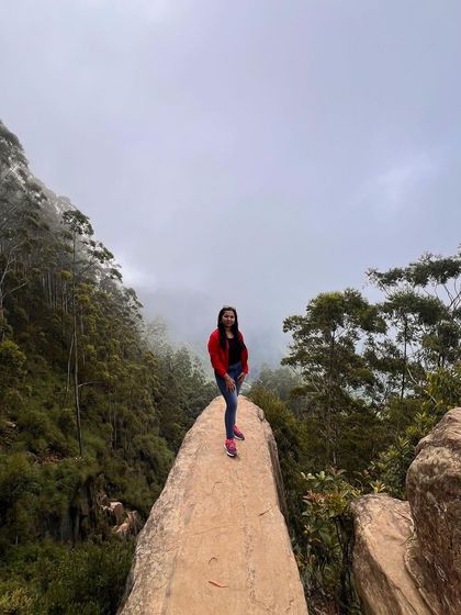 A trekker standing on Dolphin's Nose in Kodaikanal.