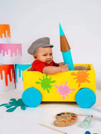 Holding a giant crayon with a happy smile. Our themed shoots are designed to be interactive and fun for the baby, resulting in natural and joyful expressions.