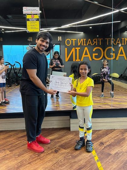 Presenting another certificate to a dedicated young dancer. Each certificate represents hours of practice, learning, and a passion for dance.