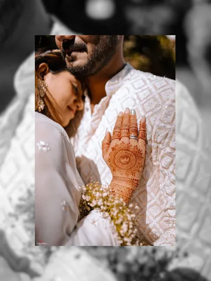 An artistic black and white edit of an intimate moment. This close-up on the bride's mehendi-adorned hand against the groom's chest is both romantic and timeless.