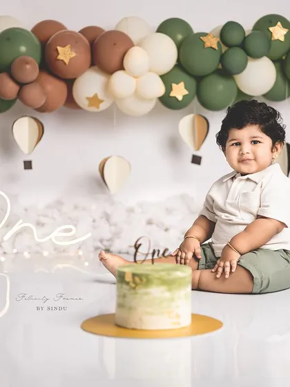 A sweet moment before the cake gets smashed. This one-year-old is contemplating his delicious birthday treat.