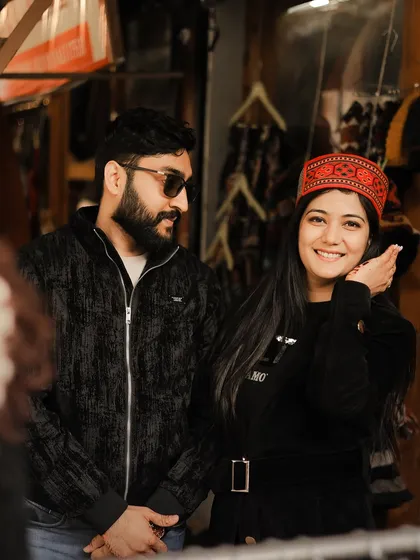 A cute shot of the bride-to-be trying on a traditional Himachali cap in a local Manali market.