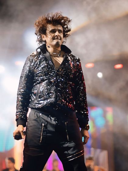 Sonu Nigam in his element, wearing a signature sequined jacket that catches the stage lights perfectly. This frame captures his dynamic presence and the rockstar energy he brings to every show.