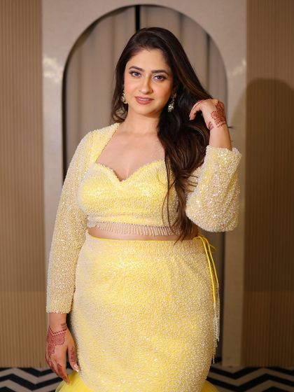 A portrait of the model in the yellow plus-size lehenga. Her confident smile is the best accessory.