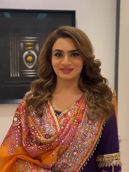 A happy client ready for her Diwali celebration, with her hair styled in glamorous, festive waves.