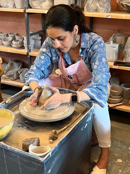 A student in deep focus, pulling up the walls of her pot. It's a challenging but incredibly rewarding process.