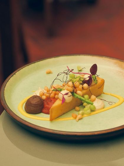 A vegetarian panisse, fried to golden perfection and served with a medley of chickpeas, sauces, and fresh herbs.