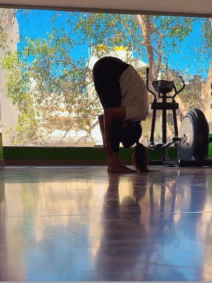 A deep standing forward fold (Uttanasana) after a workout. This is one of the best stretches for the hamstrings and back, helping to release tension and improve flexibility.