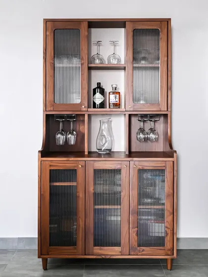 The Sky Bar Cabinet is a customizable teak unit that blends traditional Indian design with modern aesthetics. It features fluted glass, wine glass racks, and adjustable shelves to elevate your home entertaining space.