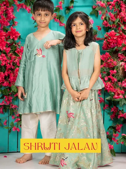 A brother and sister in a cool mint green. His angrakha kurta with bird embroidery is the perfect partner to her peplum top lehenga with the same motif.