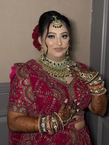 A beautiful portrait of the bride, showcasing her intricate jewellery and flawless makeup. The red floral bun adds a traditional yet stylish element to her look.