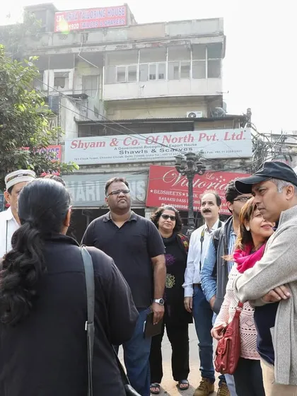 A group on a walk in Nai Sadak, discussing its transformation from a site of public spectacle and gambling to a bustling book market.