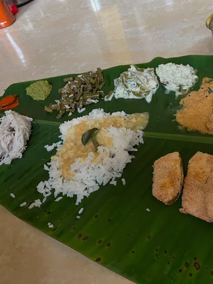 A traditional South Indian meal served on a banana leaf, featuring rice, sambar, various vegetable preparations, and fried fish. You can incorporate cultural foods into a balanced diet.