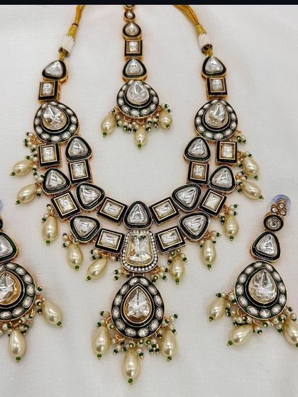 A Moissanite Polki necklace set with a dark enamel border, giving it a modern and sophisticated look.