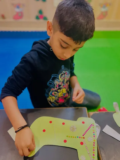 This boy is focused on adding details to his stocking craft.
