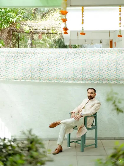 Another stylish portrait of the groom, framed by lush greenery. His relaxed yet confident posture makes this a standout photo.