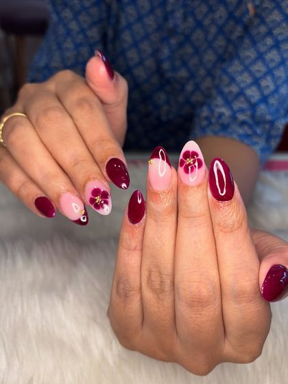 Another angle of the maroon manicure with blooming flower art.